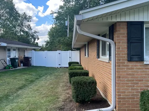 A tidy side yard with mulched beds and clean grass after the crew finished.